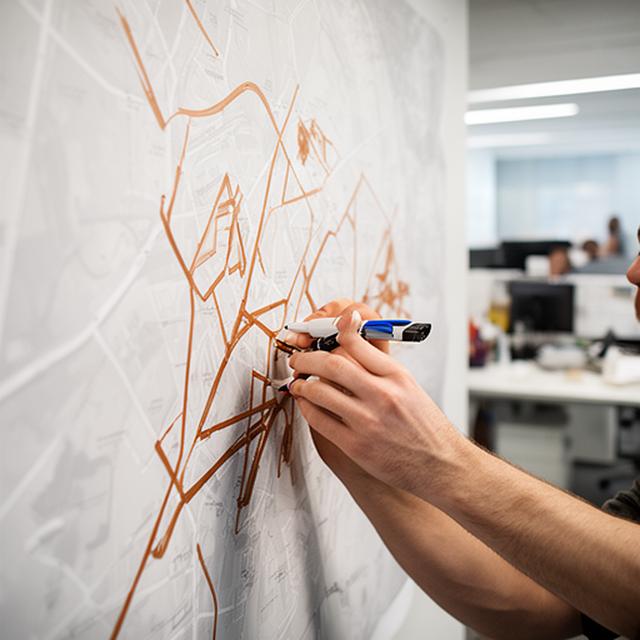 Route planner marking delivery zones on a logistics office wall map